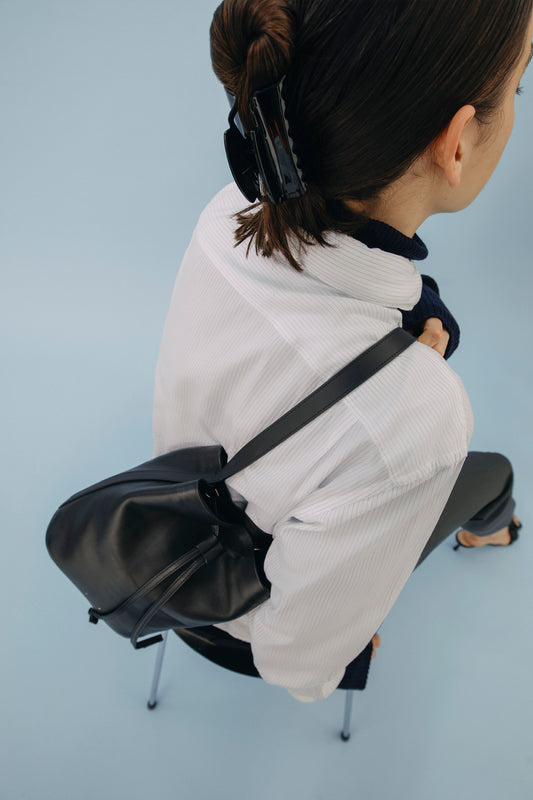 Model wearing the AB 103.1 in black over the shoulder